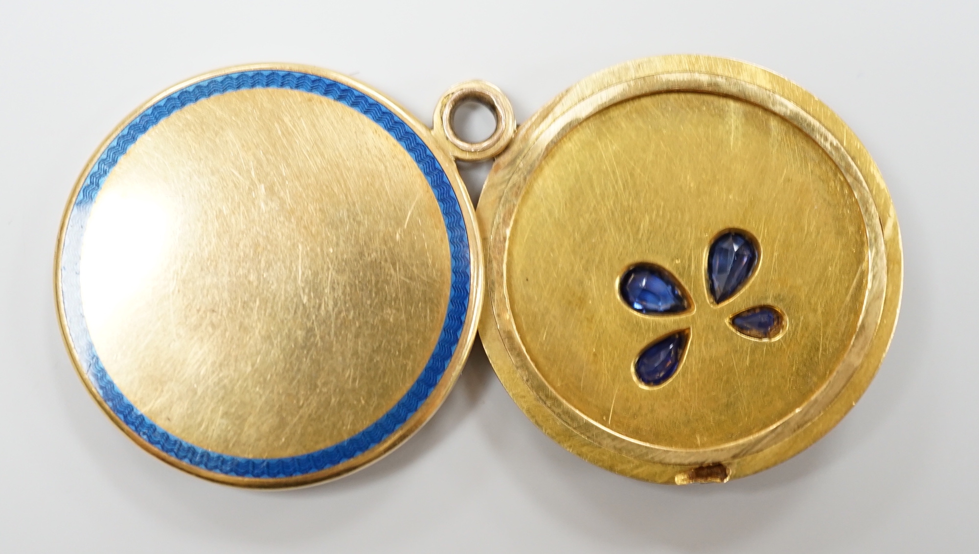 An Art Deco yellow metal, three colour enamel, synthetic? sapphire and diamond set circular locket, with clover motif, diameter 29mm